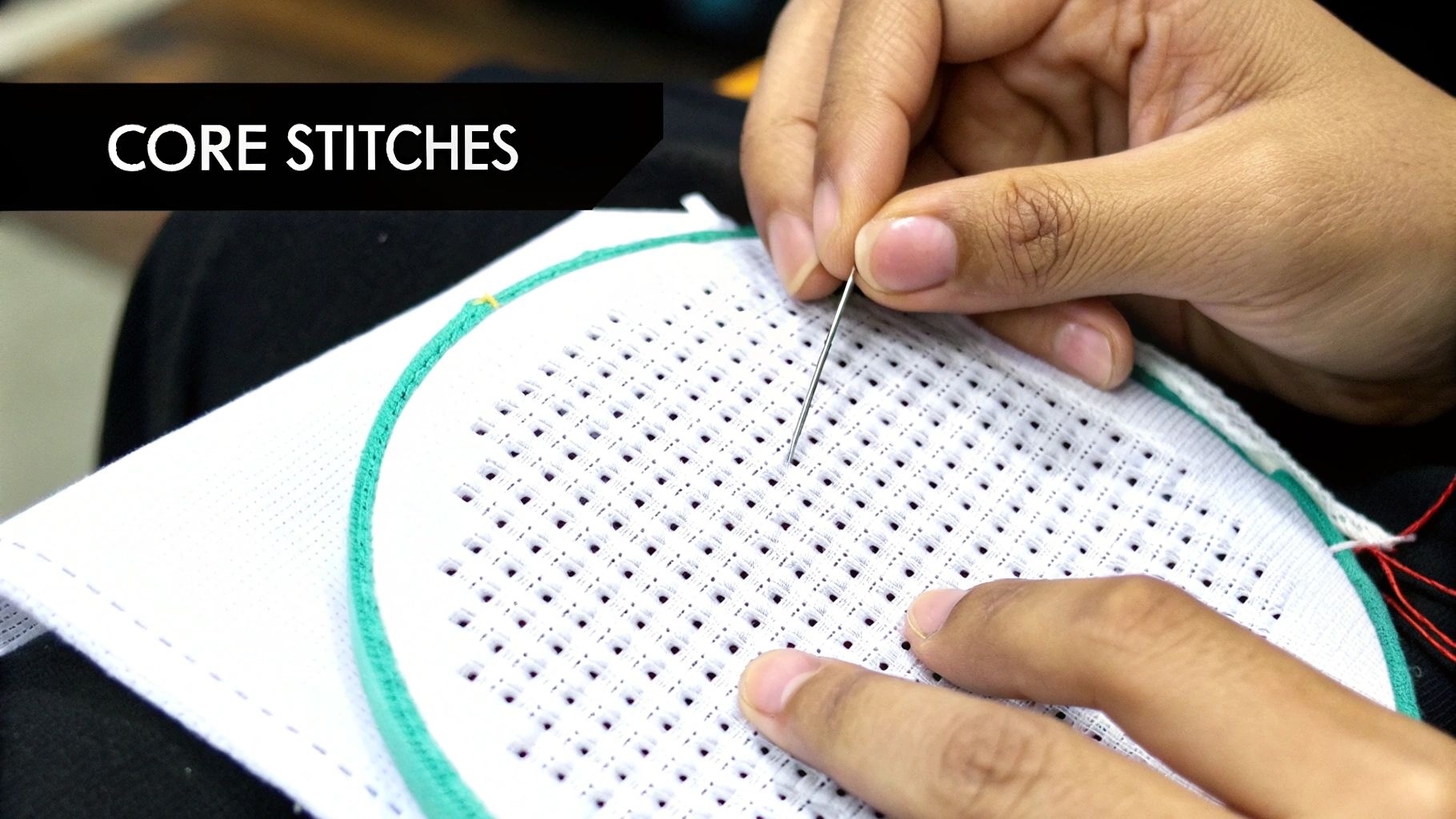 Close-up of hands doing cross-stitch on white fabric in an embroidery hoop, with 'CORE STITCHES' text.