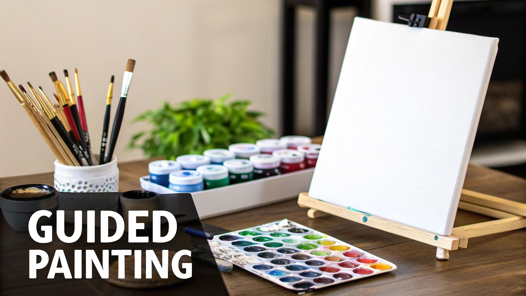 A painting station with brushes, paint pots, a watercolor palette, and a blank canvas on an easel.