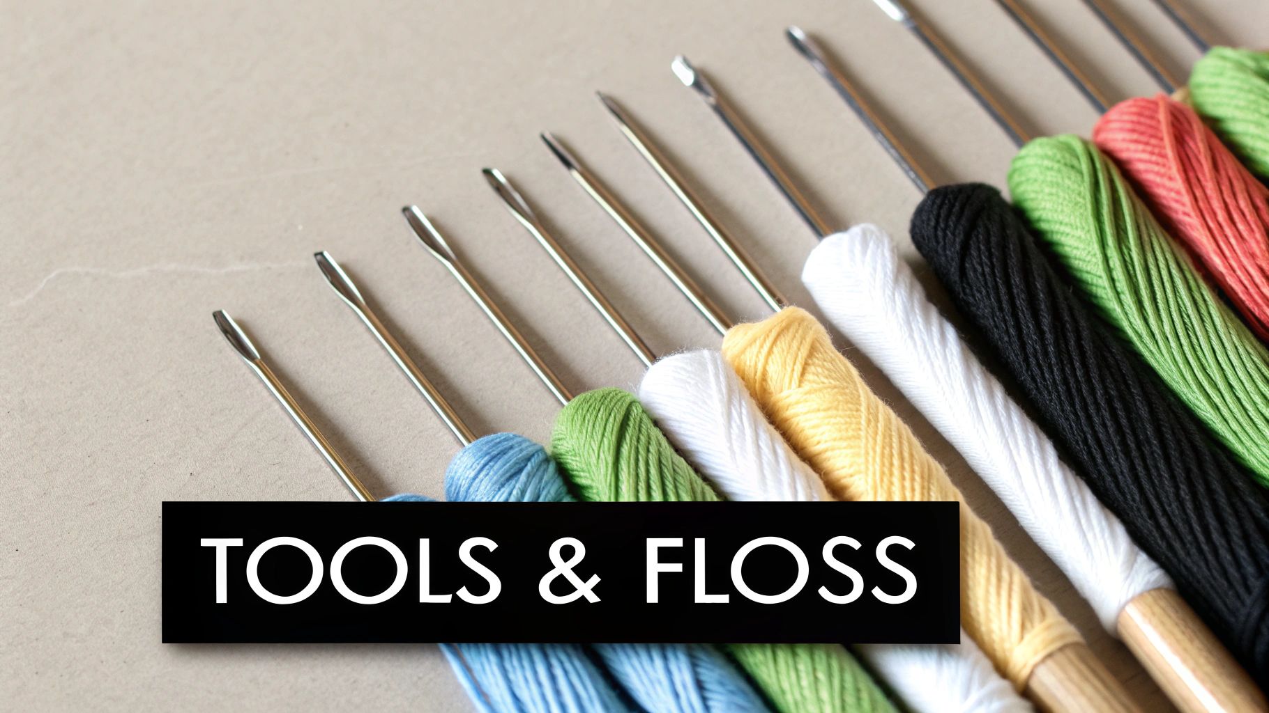 A close-up of colorful embroidery floss skeins and needles ready for a cross-stitch project.