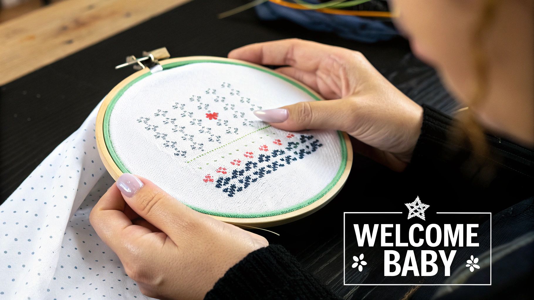 A finished cross stitch baby announcement featuring a baby's name, birthdate, and cute animal motifs, held in a wooden embroidery hoop.