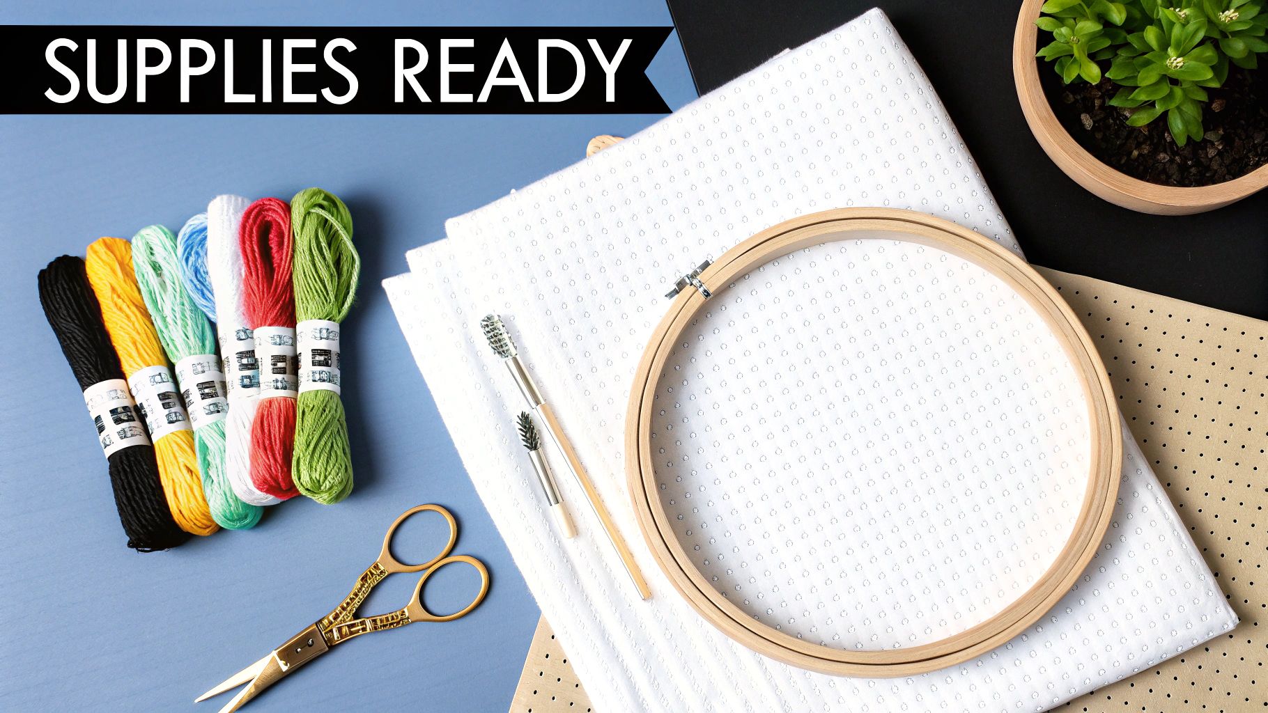 A flat lay of vibrant cross-stitch embroidery supplies, including floss, fabric, hoop, and scissors, ready for crafting.