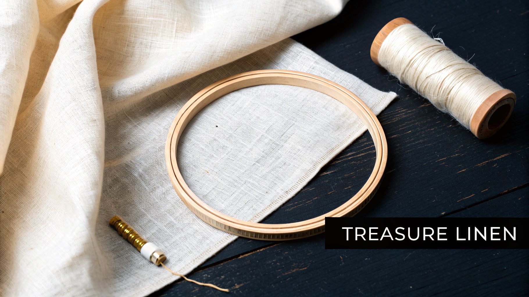 Embroidery supplies including a wooden hoop, linen fabric, a spool of thread, and a punch needle on a dark wooden background, with text 'TREASURE LINEN'.