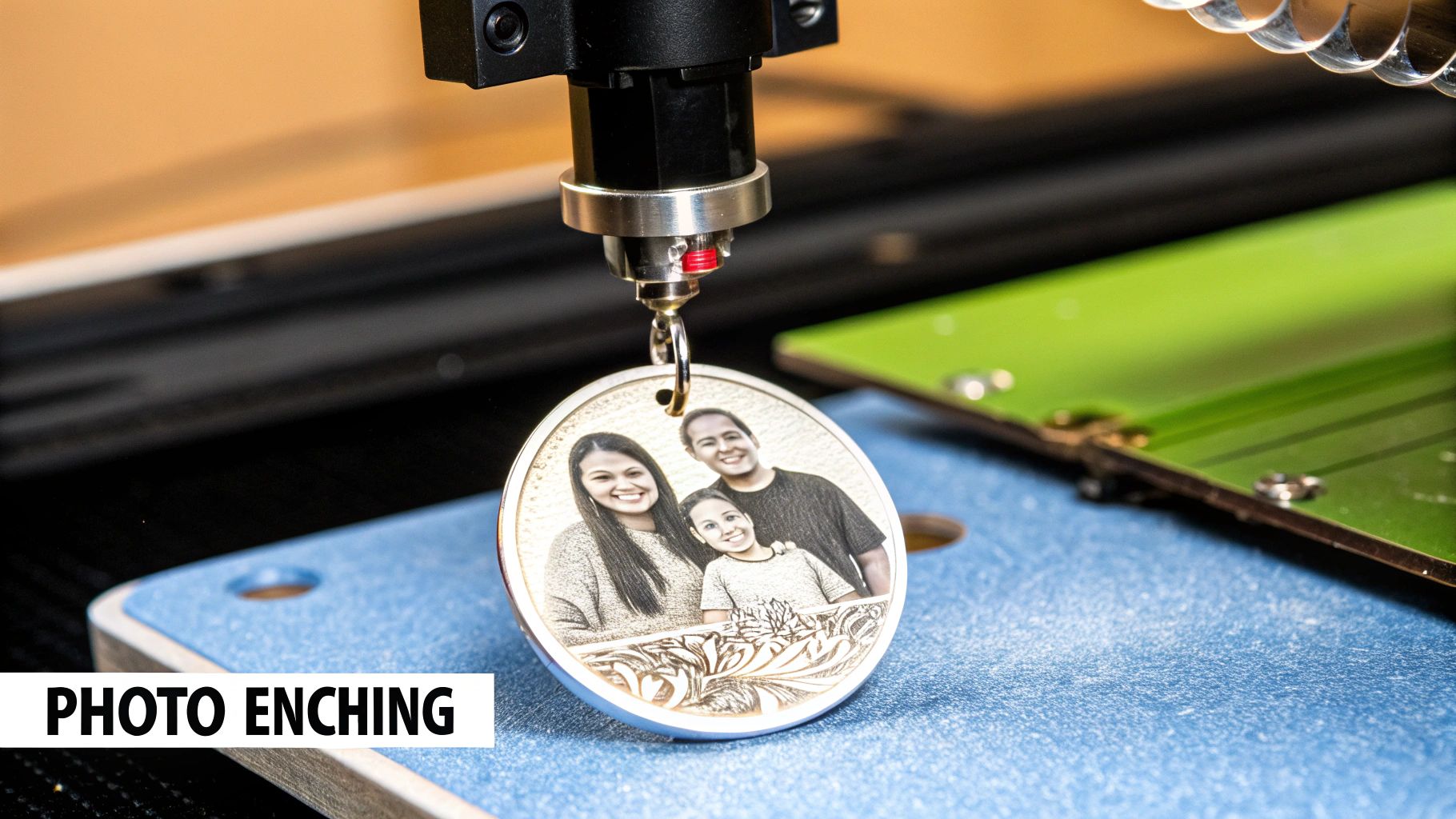 A laser machine in the process of engraving a detailed photograph onto a small metal pendant.