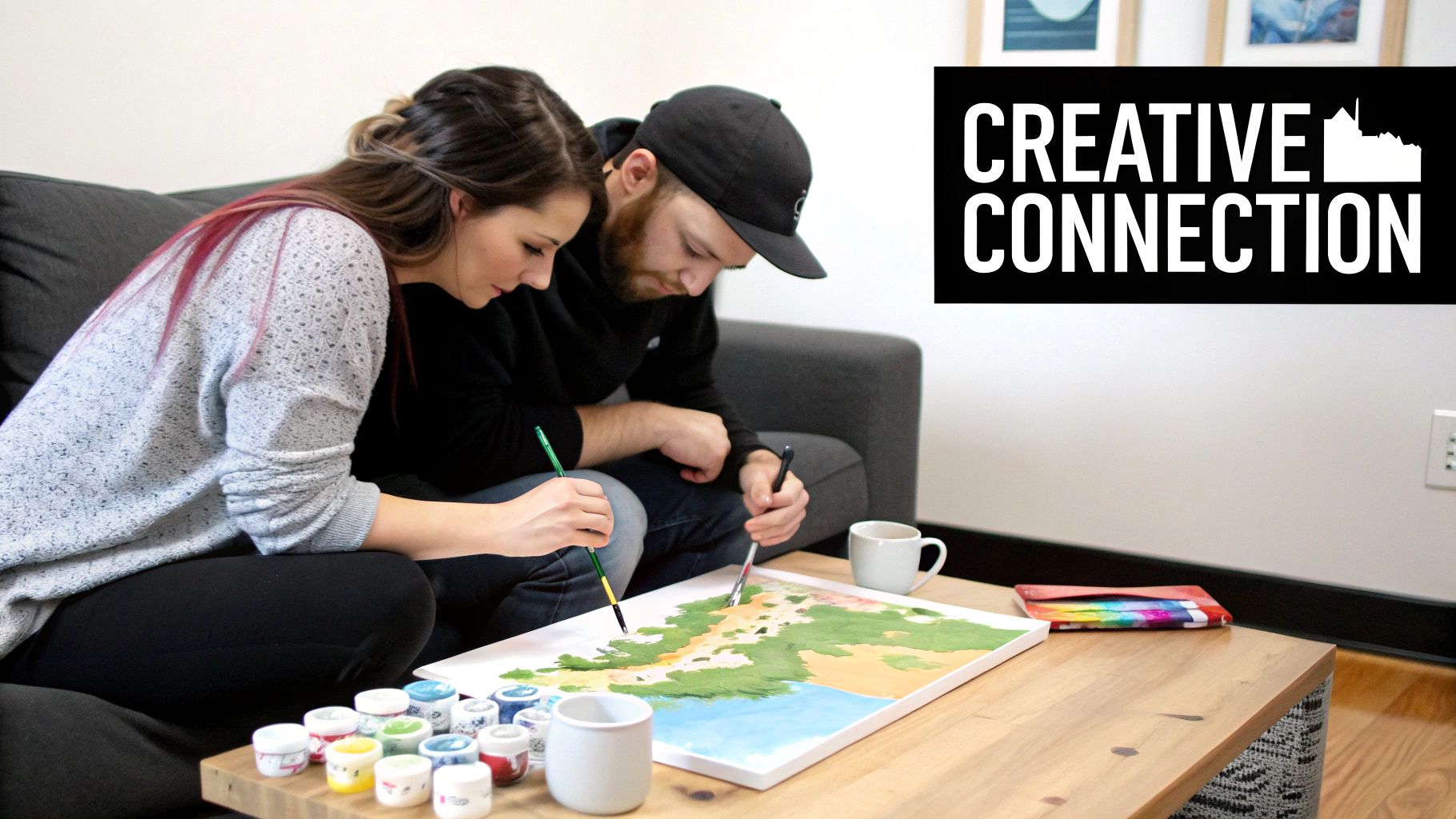 A couple smiling and painting a canvas together at home for a date night