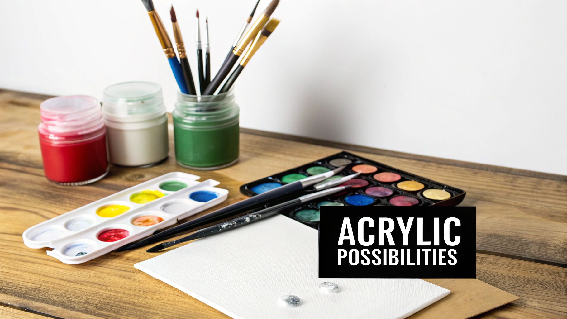 Various art supplies, including paintbrushes, pots of paint, watercolor palettes, and a canvas, on a wooden table, with text saying 'ACRYLIC POSSIBILITIES'.