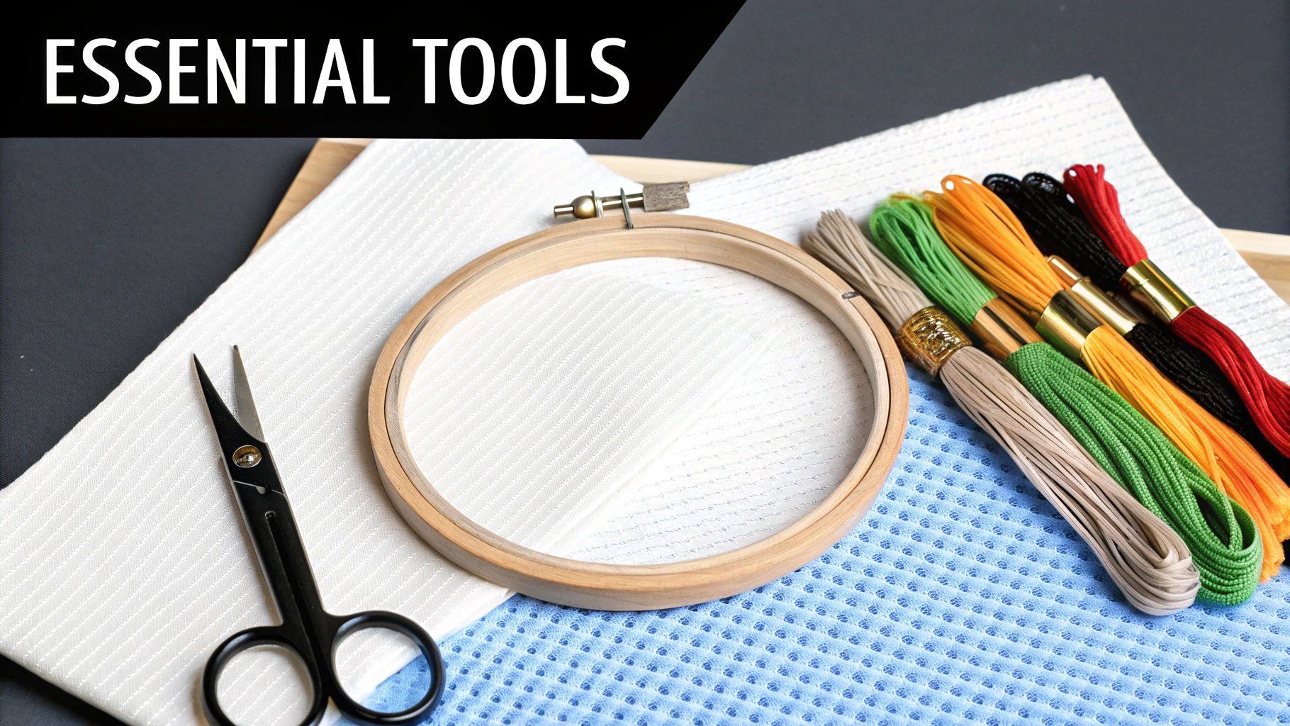 A cross-stitch kit with needles, scissors, and colorful embroidery floss arranged neatly.