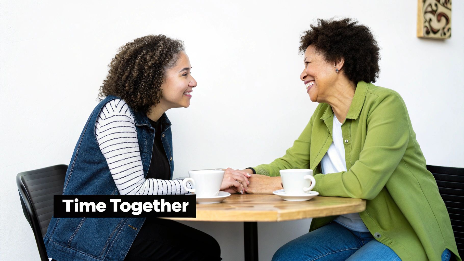 A mother and daughter laughing together on a park bench