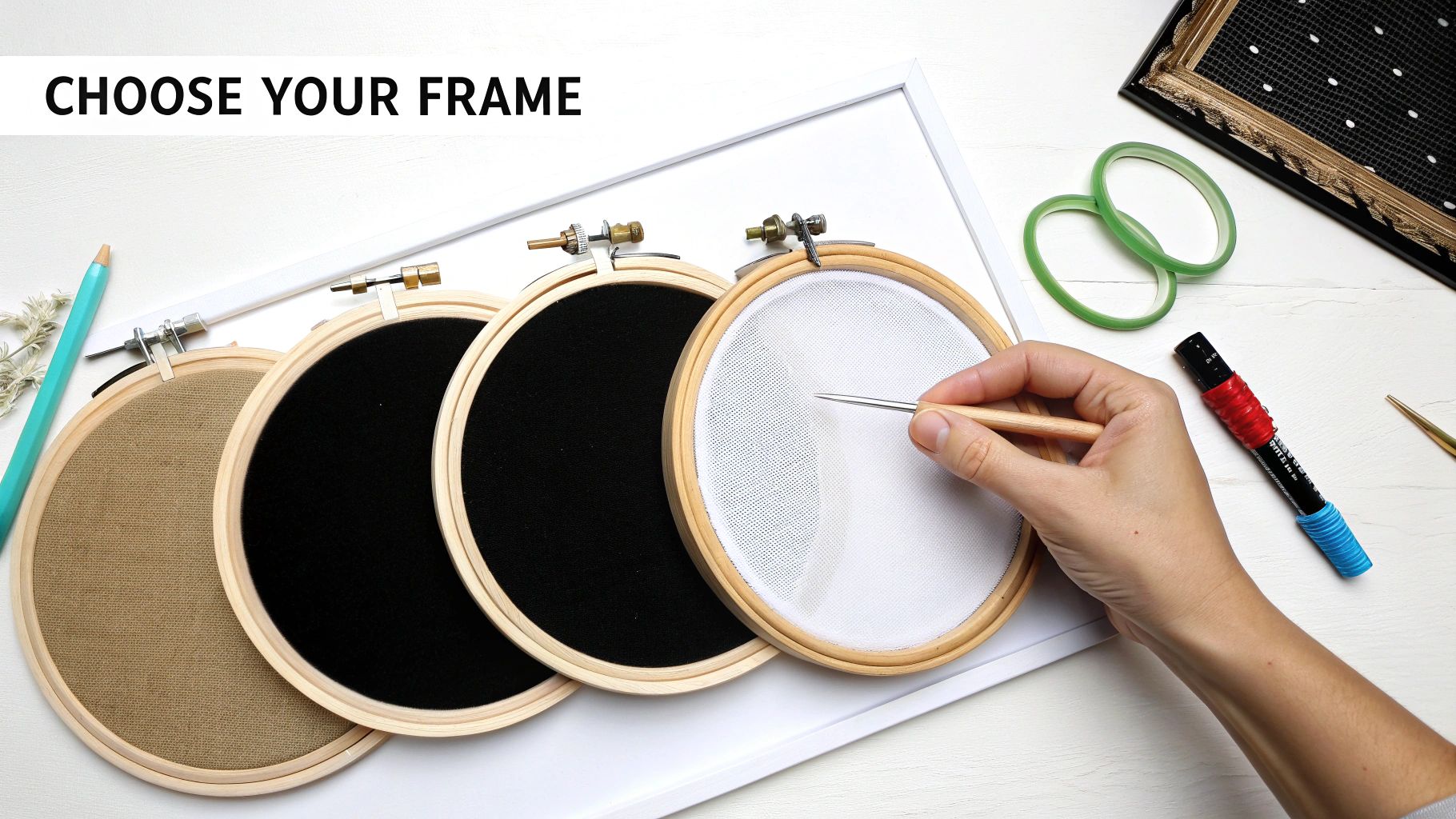 A flat lay shows various embroidery hoops with different fabric, a hand with a punch needle, and crafting supplies.