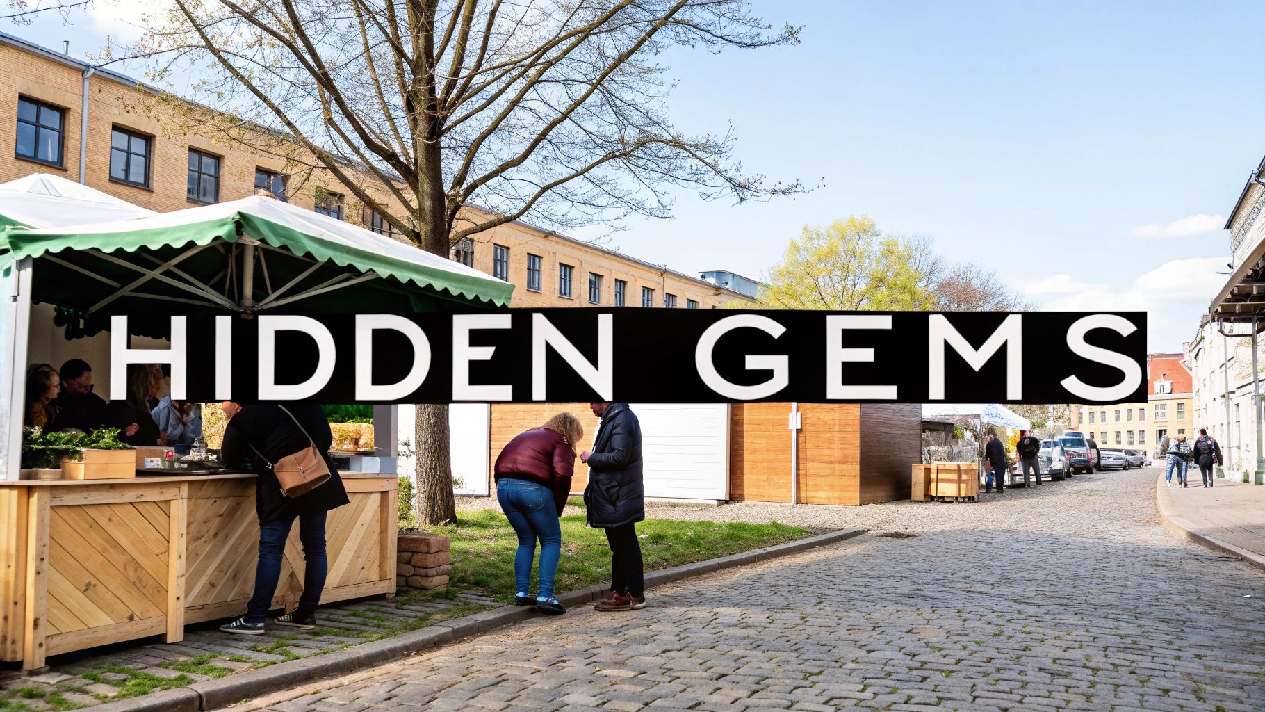 Outdoor market stalls and people gathering in cobblestone plaza near buildings with bare trees