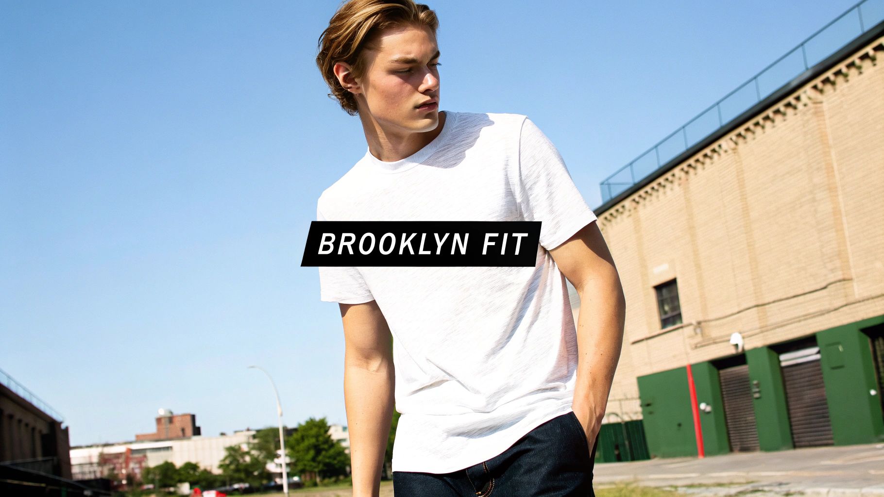 A young man models a white t-shirt and dark jeans with a 'BROOKLYN FIT' banner.