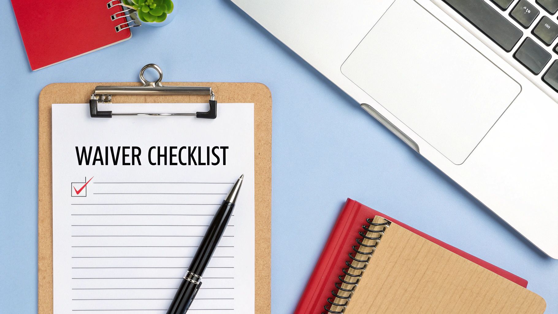 A waiver checklist on a clipboard with a pen, surrounded by a laptop, notebooks, and a plant.