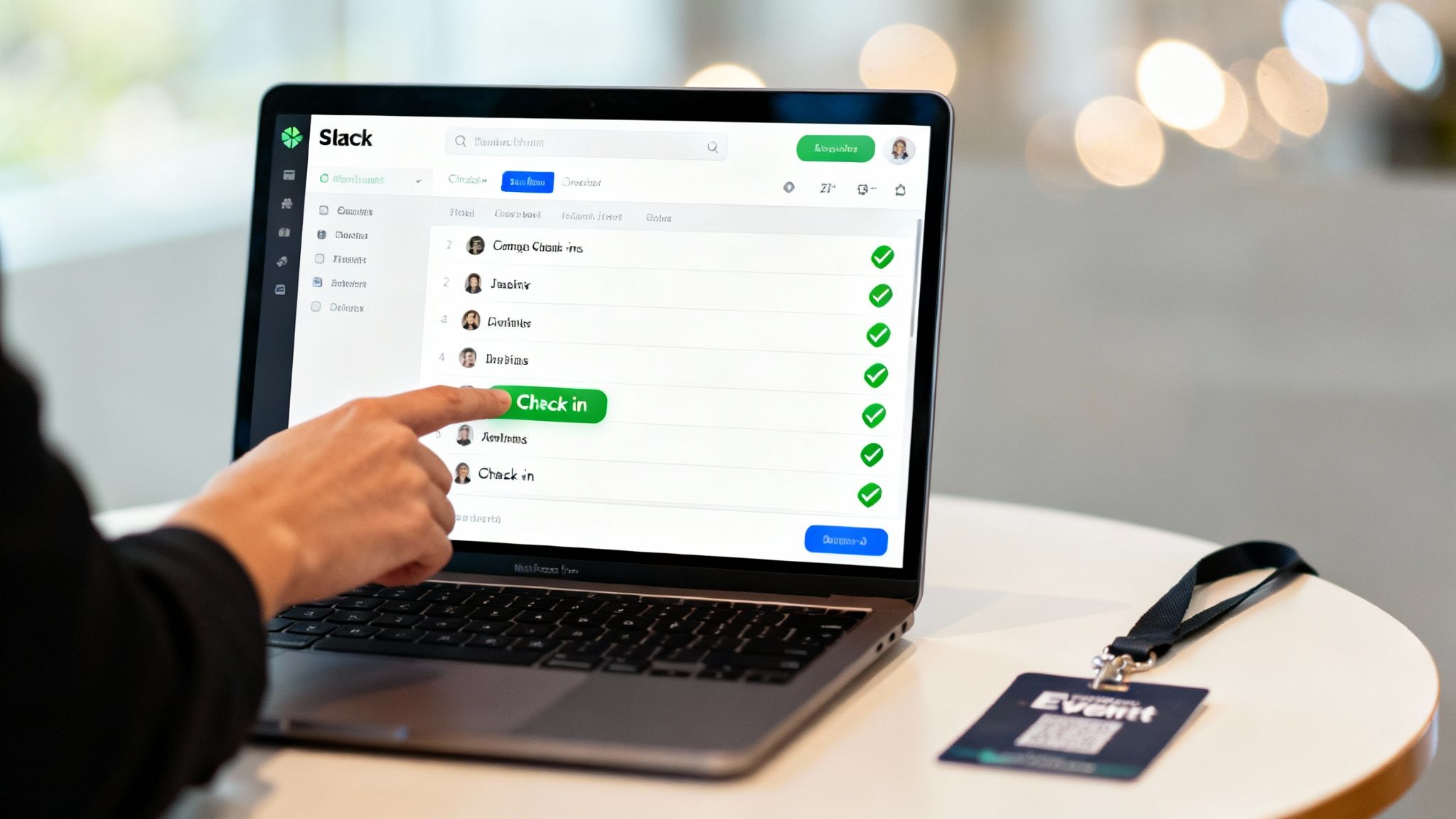 An organized event check-in desk with a laptop open to a Slack channel.
