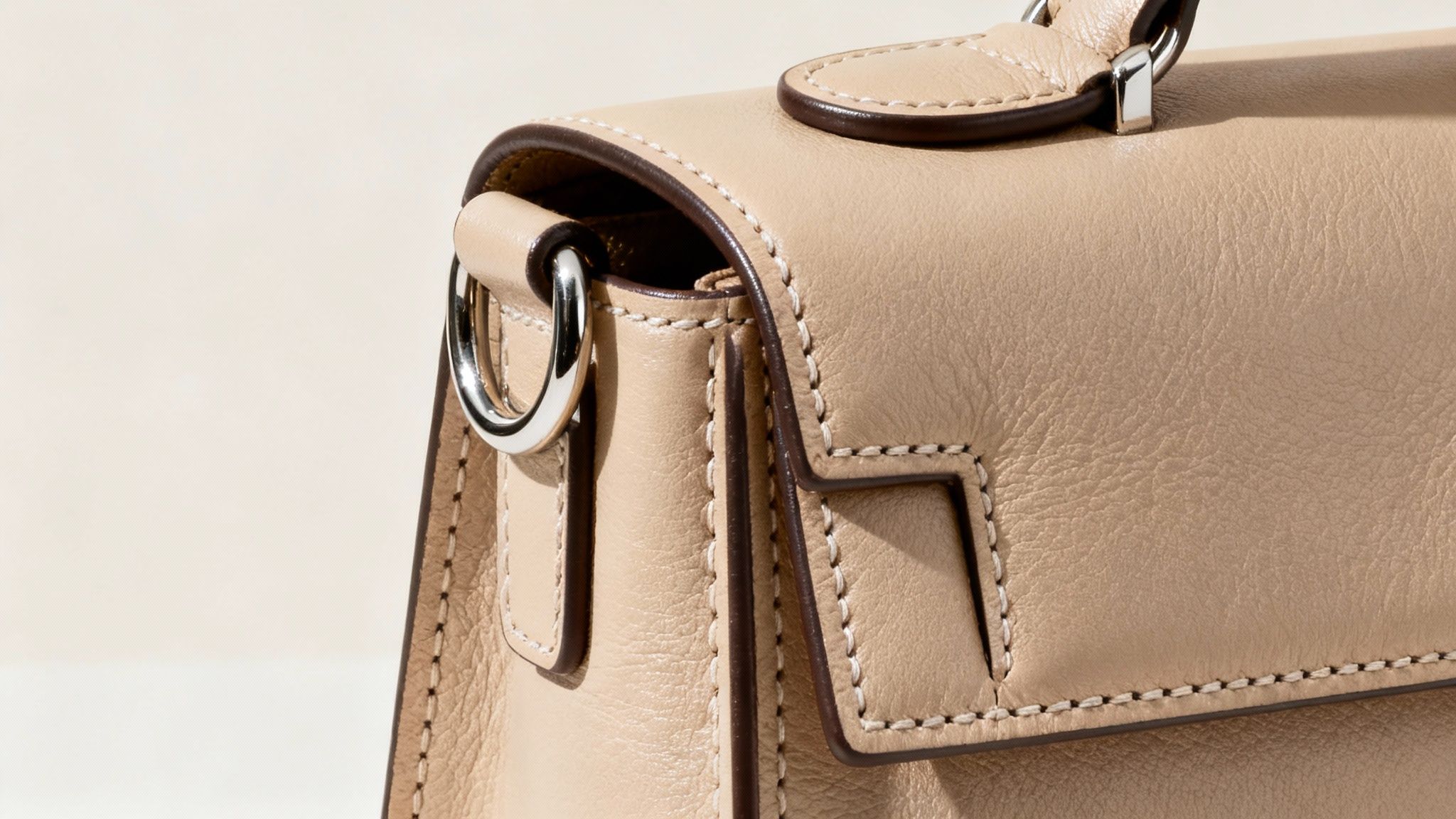 A close-up shot of the detailed stitching and high-quality leather on a designer handbag.