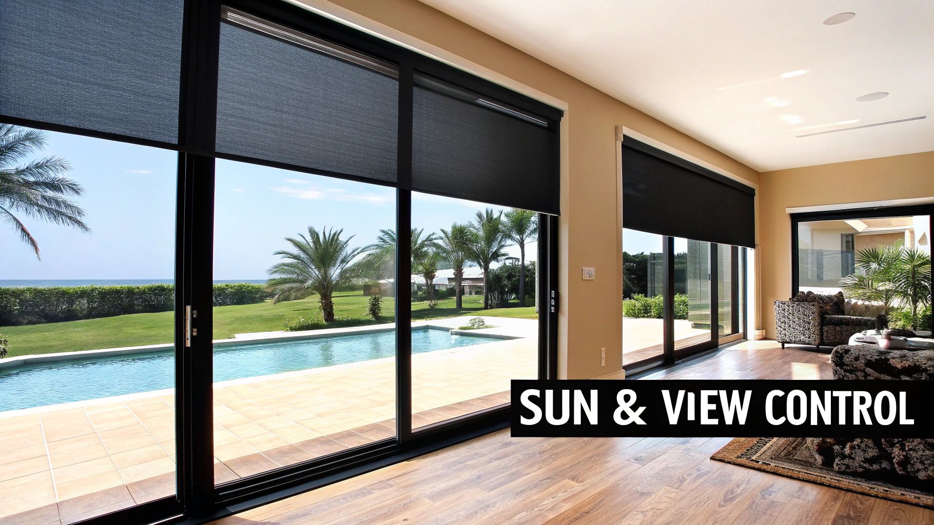 Modern room with sliding glass doors, dark solar shades partially drawn, overlooking a pool and ocean.